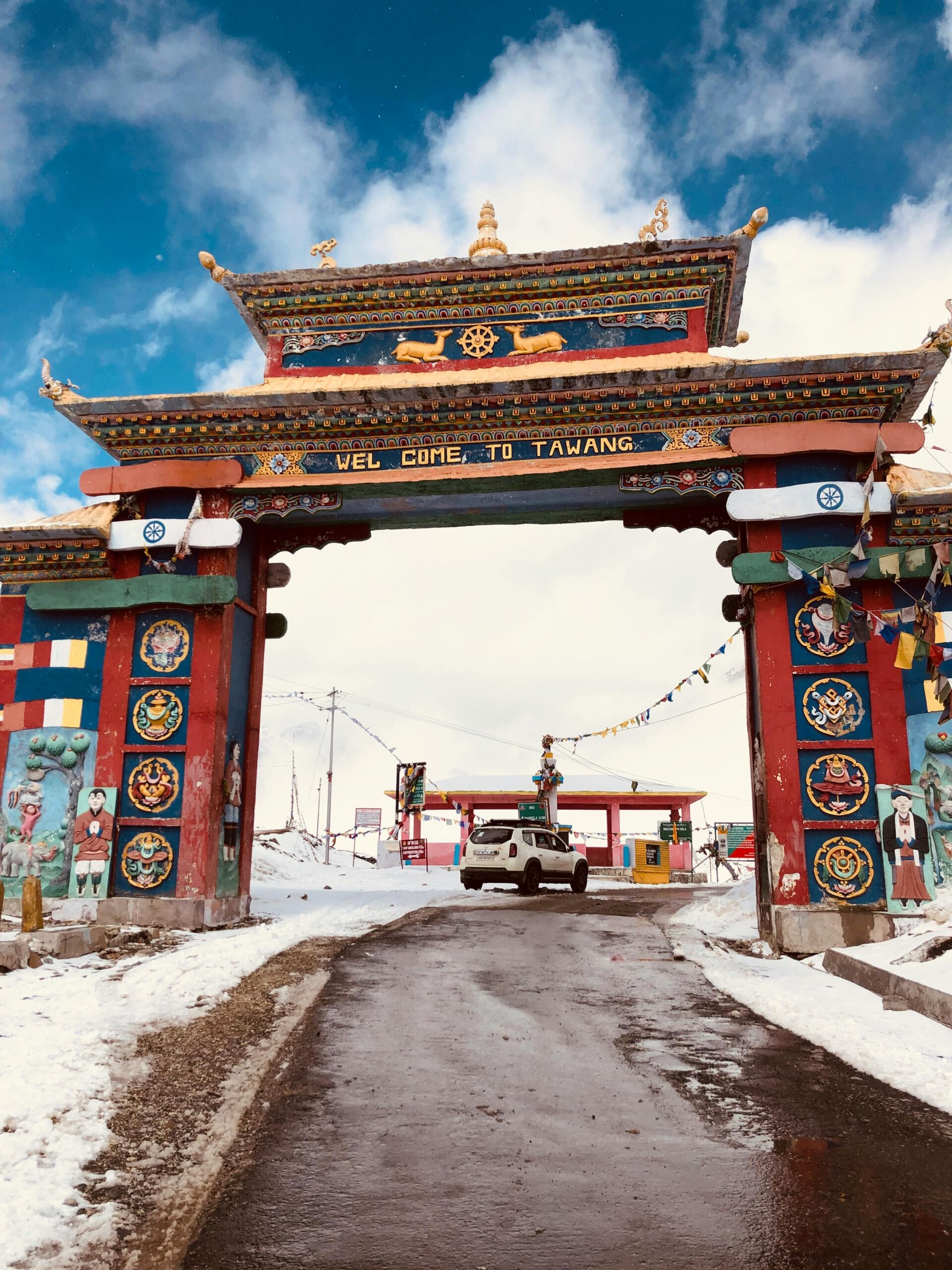 Explore the vibrant Tawang gate amidst snow, capturing traditional architecture and scenic beauty.