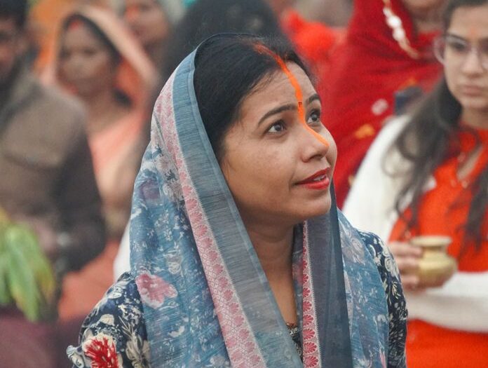 Women dressed in colorful attire participate in a cultural festival outdoors.